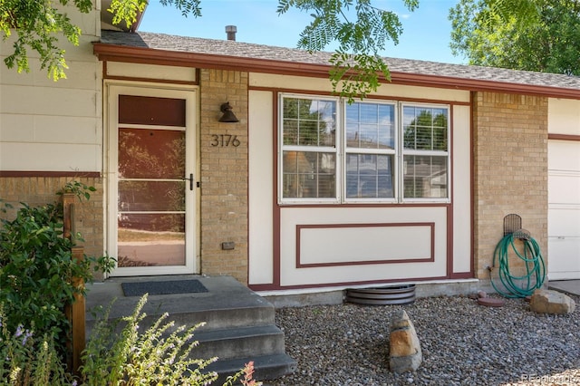 3176 S Alton Ct, Denver, CO 80231 - view of exterior entry with brick siding and a shingled roof