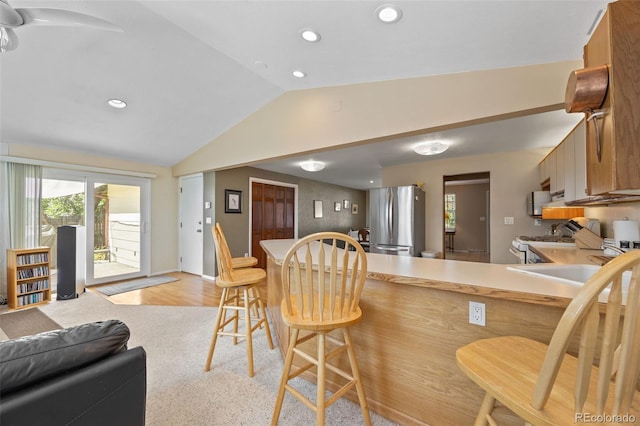 3176 S Alton Ct, Denver, CO 80231 - kitchen with freestanding refrigerator, lofted ceiling, white gas range, healthy amount of natural light, and recessed lighting