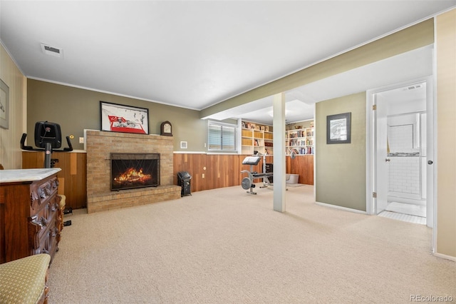 3176 S Alton Ct, Denver, CO 80231 - carpeted living area featuring a fireplace, wooden walls, crown molding, and a wainscoted wall