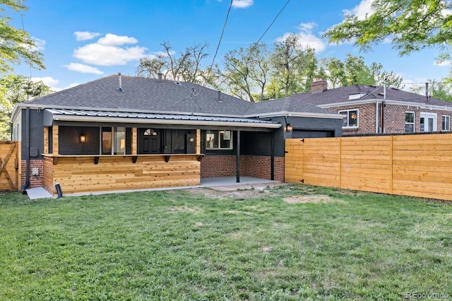 rear view of property with a yard