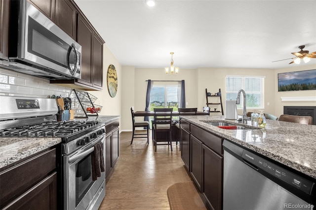 91 S Quantock St, Aurora, CO 80018 - kitchen with stainless steel appliances, a chandelier, plenty of natural light, and dark brown cabinets