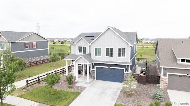 91 S Quantock St, Aurora, CO 80018 - view of front of house featuring board and batten siding, driveway, a garage, solar panels, and stone siding