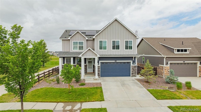 91 S Quantock St, Aurora, CO 80018 - craftsman-style home with board and batten siding, concrete driveway, solar panels, an attached garage, and stone siding