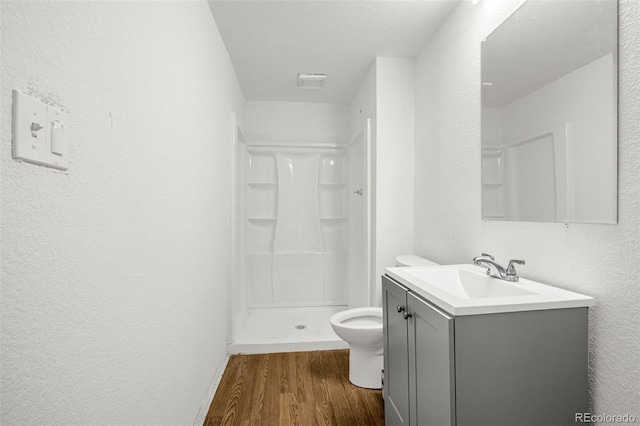 91 S Quantock St, Aurora, CO 80018 - bathroom featuring wood finished floors, vanity, a stall shower, and a textured wall
