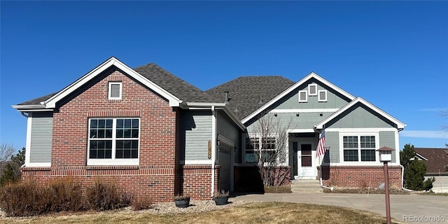 bungalow-style home with a garage and brick siding