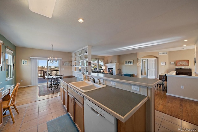 kitchen with open floor plan, a sink, visible vents, and white dishwasher