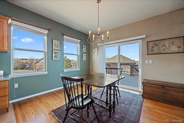 dining space featuring an inviting chandelier, baseboards, and light wood-type flooring