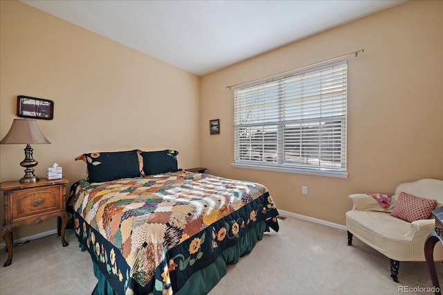 bedroom with light carpet and baseboards