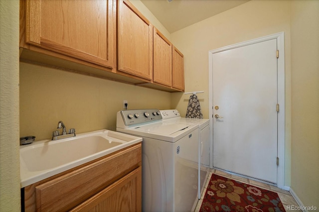 laundry area featuring a sink, baseboards, cabinet space, and washer and clothes dryer