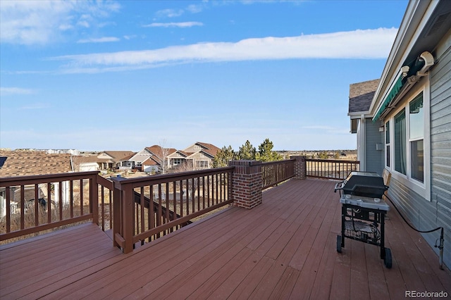 wooden terrace featuring area for grilling and a residential view