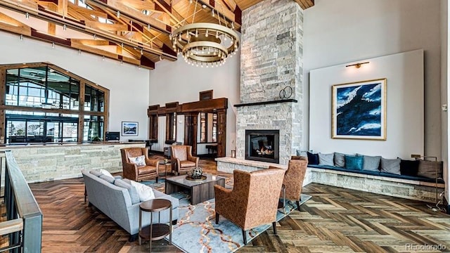 living room with beam ceiling, a stone fireplace, and a towering ceiling