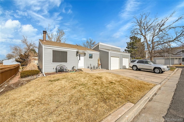 view of front of house featuring a garage, an outdoor structure, and a front lawn