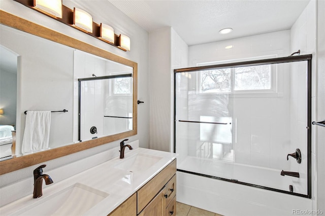 bathroom with tile patterned flooring, vanity, a textured ceiling, and shower / bath combination with glass door