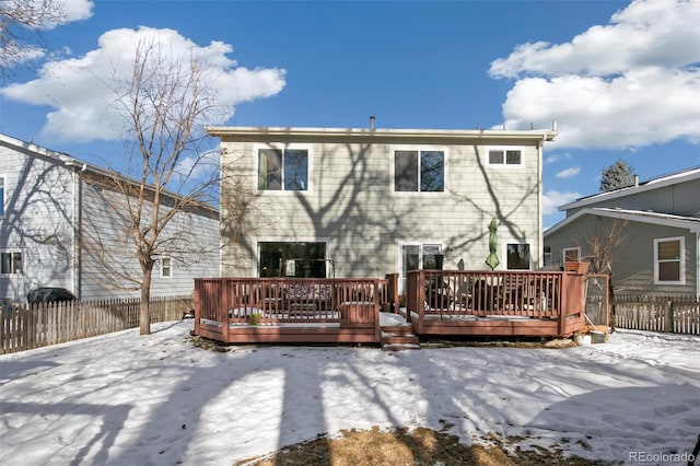 snow covered rear of property featuring a deck