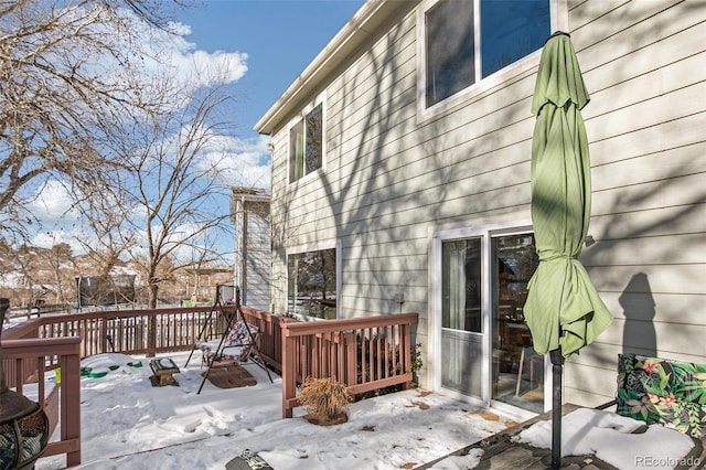 snow covered deck with a trampoline