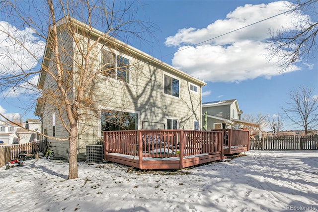 snow covered back of property featuring a deck and central air condition unit