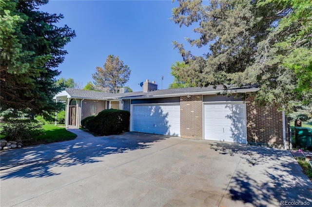 3561 Kalispell St, Aurora, CO 80011 - view of front of property with concrete driveway, brick siding, a chimney, and an attached garage