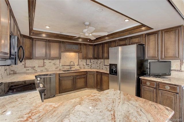 3561 Kalispell St, Aurora, CO 80011 - kitchen featuring appliances with stainless steel finishes, decorative backsplash, ceiling fan, a raised ceiling, and light stone counters