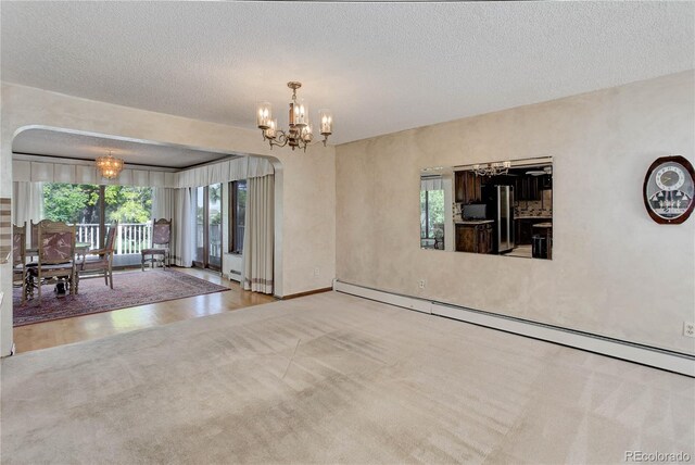 3561 Kalispell St, Aurora, CO 80011 - carpeted spare room with a chandelier, a baseboard radiator, and a textured ceiling