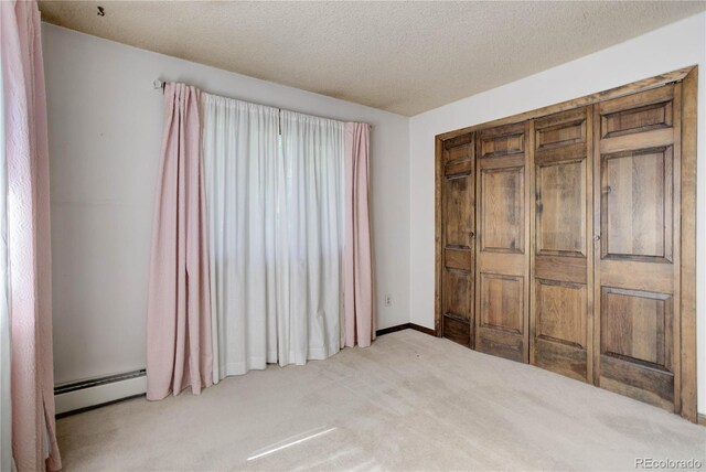 3561 Kalispell St, Aurora, CO 80011 - carpeted bedroom featuring a baseboard heating unit and a textured ceiling