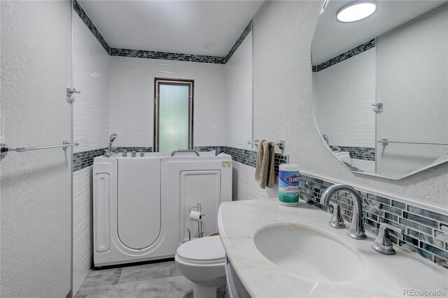 3561 Kalispell St, Aurora, CO 80011 - full bath featuring a textured wall, decorative backsplash, vanity, and a bath