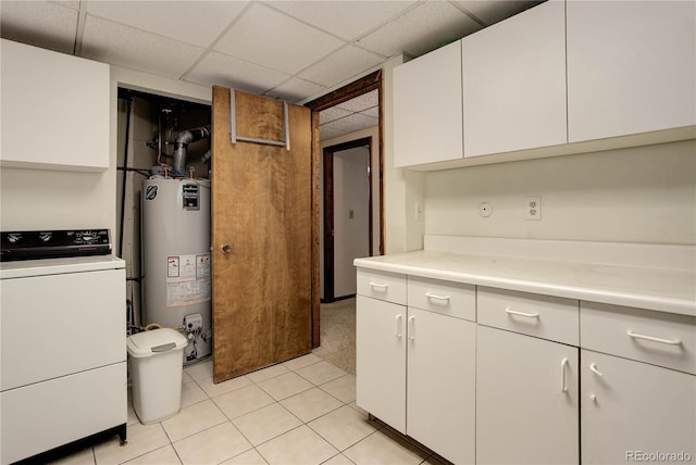 3561 Kalispell St, Aurora, CO 80011 - kitchen featuring washer / clothes dryer, water heater, white cabinets, light countertops, and a paneled ceiling