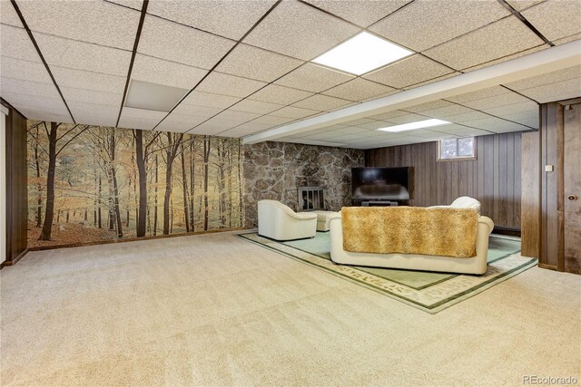 3561 Kalispell St, Aurora, CO 80011 - carpeted living area featuring a paneled ceiling, wooden walls, and baseboard heating