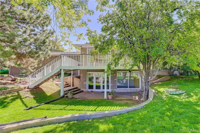 3561 Kalispell St, Aurora, CO 80011 - rear view of property featuring brick siding, a wooden deck, a yard, stairs, and a patio