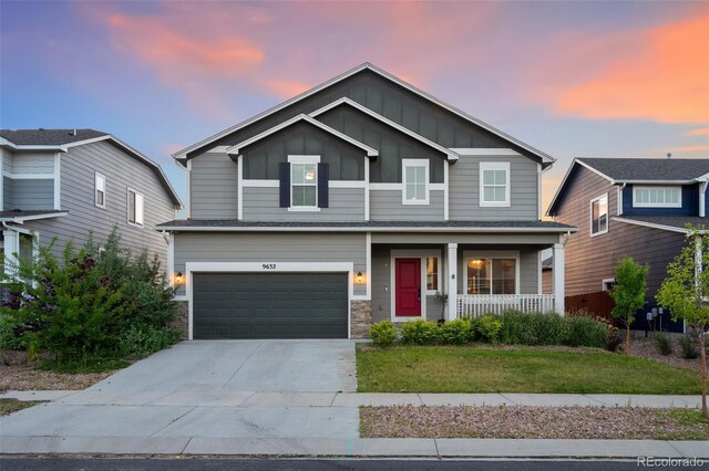 9632 Emerald Vista Dr, Peyton, CO 80831 - view of front of home with a porch, board and batten siding, a garage, driveway, and a lawn