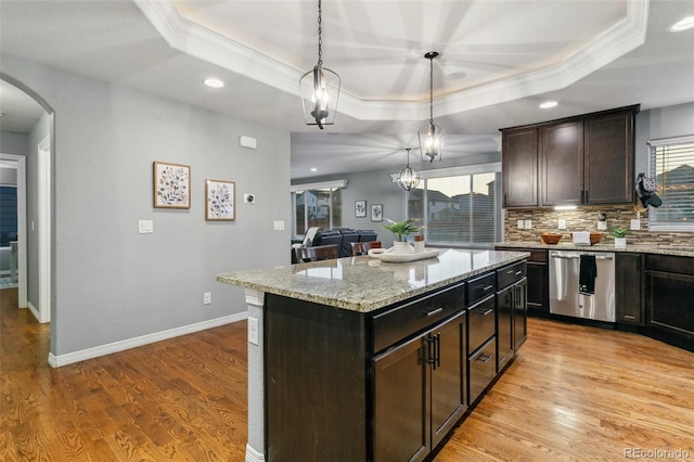 9632 Emerald Vista Dr, Peyton, CO 80831 - kitchen featuring stainless steel dishwasher, crown molding, a tray ceiling, arched walkways, and decorative backsplash