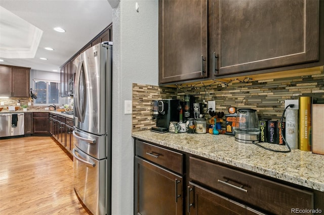 9632 Emerald Vista Dr, Peyton, CO 80831 - kitchen with stainless steel appliances, backsplash, dark brown cabinetry, light stone counters, and recessed lighting