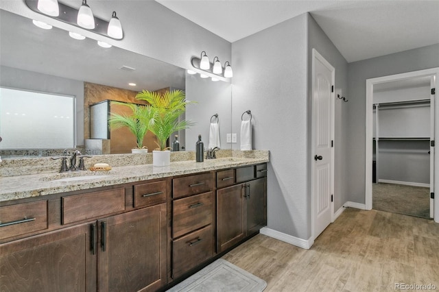 9632 Emerald Vista Dr, Peyton, CO 80831 - full bath featuring double vanity, wood finished floors, a spacious closet, and a shower with shower door