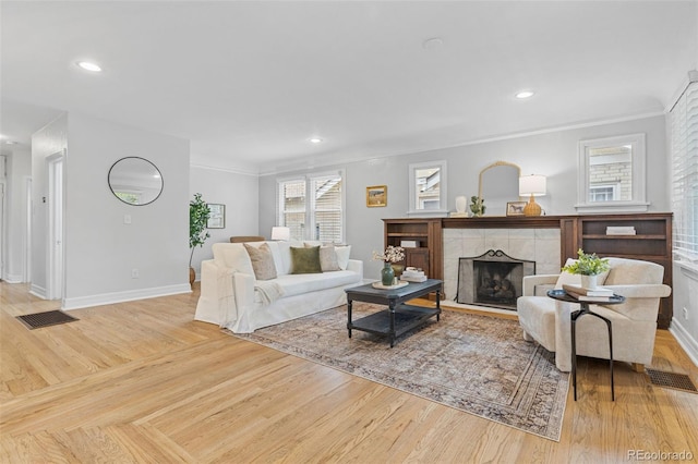 3334 W 37th Ave, Denver, CO 80211 - living area with wood finished floors, baseboards, a tile fireplace, ornamental molding, and recessed lighting