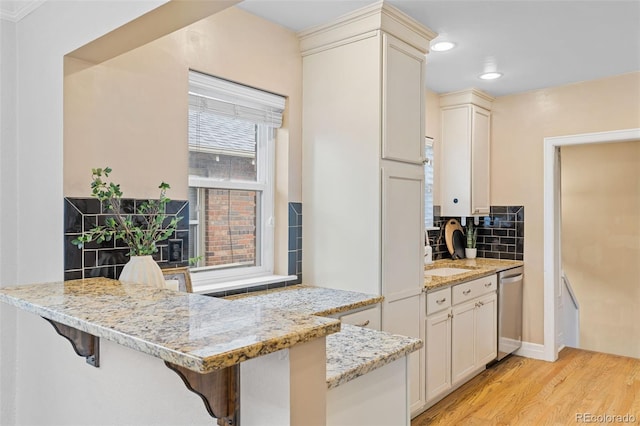 3334 W 37th Ave, Denver, CO 80211 - kitchen featuring stainless steel dishwasher, light wood-style floors, light stone counters, recessed lighting, and tasteful backsplash