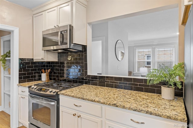3334 W 37th Ave, Denver, CO 80211 - kitchen with appliances with stainless steel finishes, backsplash, light stone countertops, white cabinetry, and light wood-type flooring