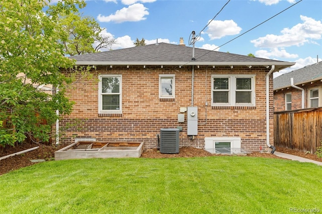 3334 W 37th Ave, Denver, CO 80211 - rear view of house featuring brick siding, central AC, roof with shingles, and a vegetable garden
