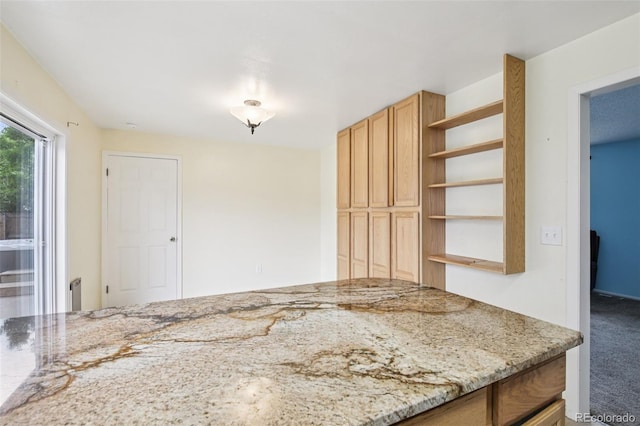7075 Welch Ct, Arvada, CO 80004 - kitchen featuring open shelves, carpet floors, and light stone counters