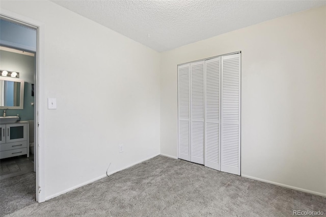 7075 Welch Ct, Arvada, CO 80004 - unfurnished bedroom with carpet, a sink, a closet, baseboards, and a textured ceiling