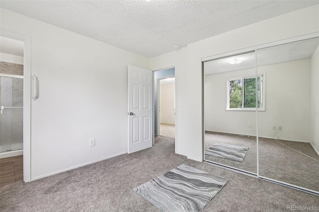 7075 Welch Ct, Arvada, CO 80004 - unfurnished bedroom featuring carpet floors, a closet, a textured ceiling, ensuite bath, and baseboards