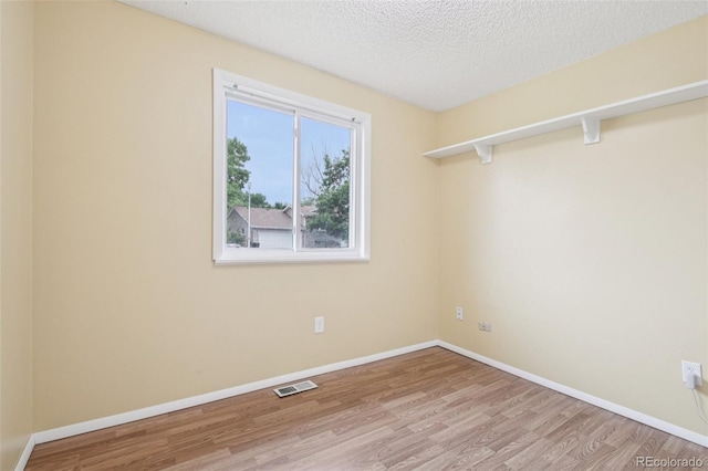 7075 Welch Ct, Arvada, CO 80004 - spare room with wood finished floors, a textured ceiling, and baseboards