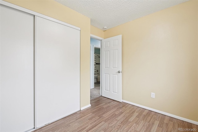 7075 Welch Ct, Arvada, CO 80004 - unfurnished bedroom featuring wood finished floors, a closet, baseboards, and a textured ceiling