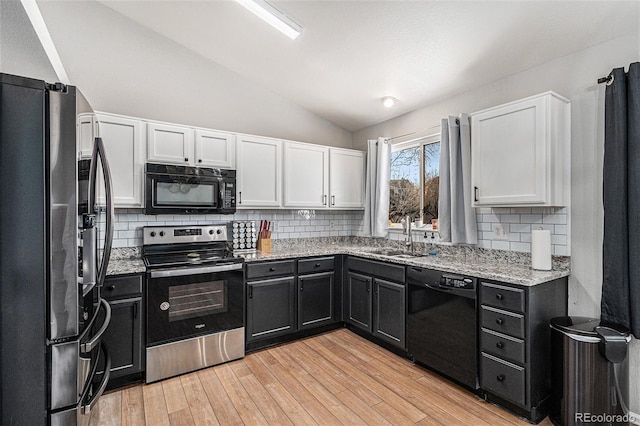 kitchen with white cabinetry, sink, vaulted ceiling, and black appliances