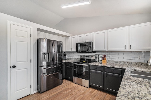 kitchen with lofted ceiling, appliances with stainless steel finishes, backsplash, white cabinets, and light wood-type flooring