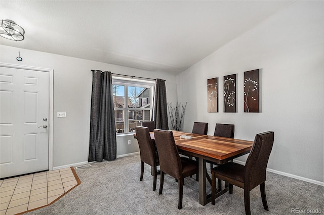 carpeted dining space featuring lofted ceiling