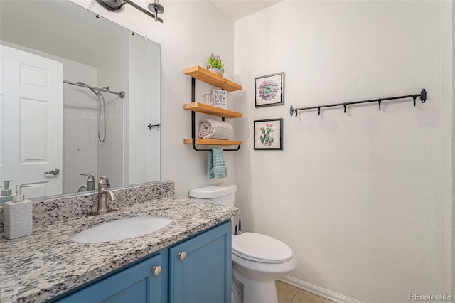 bathroom featuring vanity, tile patterned flooring, toilet, and a tile shower