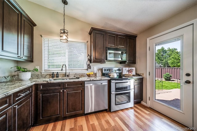 18159 E Crestline Cir, Centennial, CO 80015 - kitchen featuring appliances with stainless steel finishes, light wood-type flooring, dark brown cabinetry, and healthy amount of natural light