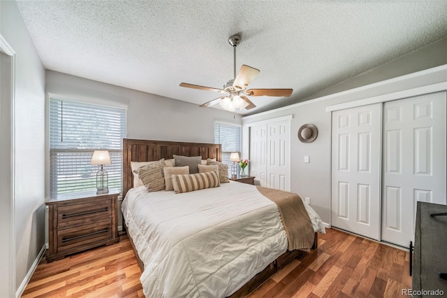 18159 E Crestline Cir, Centennial, CO 80015 - bedroom featuring two closets, a textured ceiling, light wood finished floors, and a ceiling fan