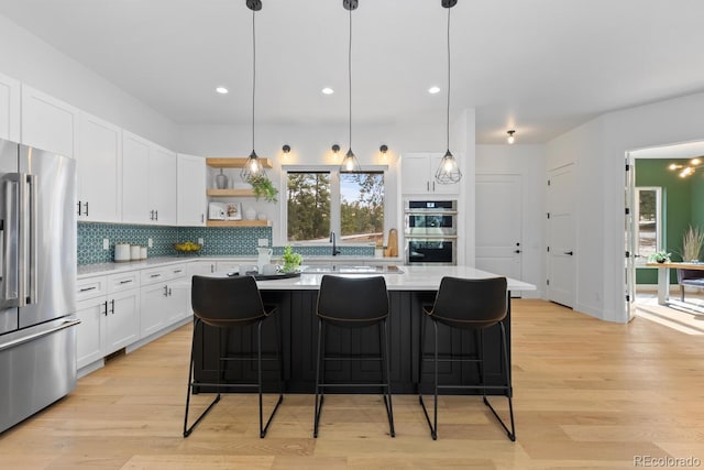 kitchen with hanging light fixtures, appliances with stainless steel finishes, and white cabinets