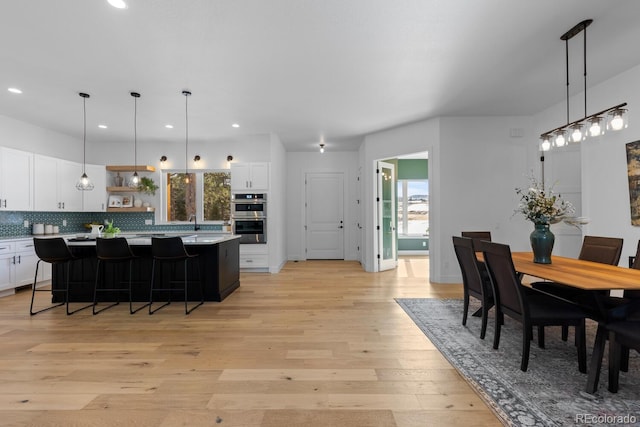 dining space with sink and light hardwood / wood-style floors