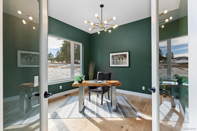 office area featuring french doors, an inviting chandelier, and hardwood / wood-style floors